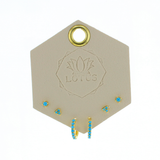 Lotus Studio Gold Trio Earrings in Eva, turquoise flower studs, star studs and turquoise huggies on a Lotus card