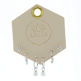 Lotus Studio Silver Trio Earrings in Audrey, dot studs, pave huggies and pearl drop hoops on a Lotus card
