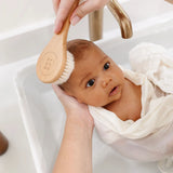 Lou Lou & Company Baby Hair Brush Set, a baby wrapped in a towel being brushed at the sink
