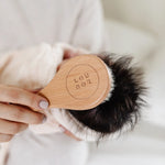 Lou Lou & Company Baby Hair Brush Set, close-up of the engraved Lou Lou wooden brush on a baby's dark hair