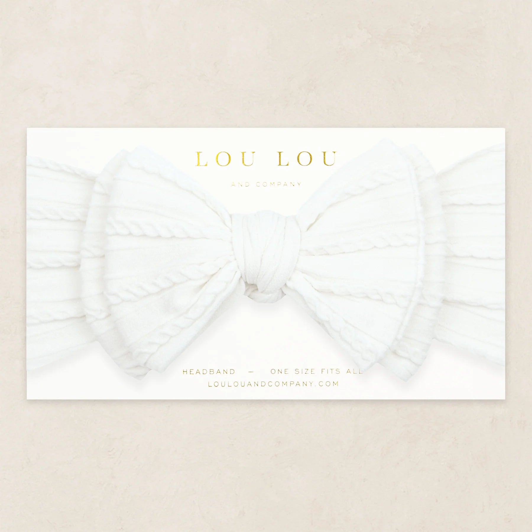 Lou Lou & Company Cable Knit Headband in Crystal White, a soft white bow headband on its card