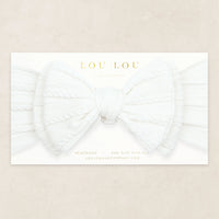 Lou Lou & Company Cable Knit Headband in Crystal White, a soft white bow headband on its card