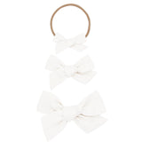 Lou Lou & Company Classic Bow in White, shown as a nylon headband and two clip bows