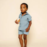 Toddler holding a ball wearing the Lou Lou & Company Cloud Muslin Shirt and Shorts in Steel