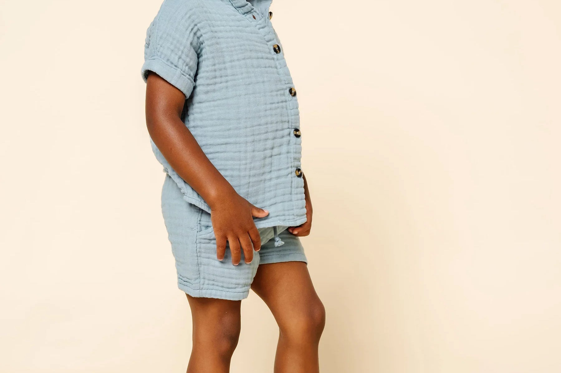 Toddler in profile wearing the Lou Lou & Company Cloud Muslin Shirt and Shorts in Steel