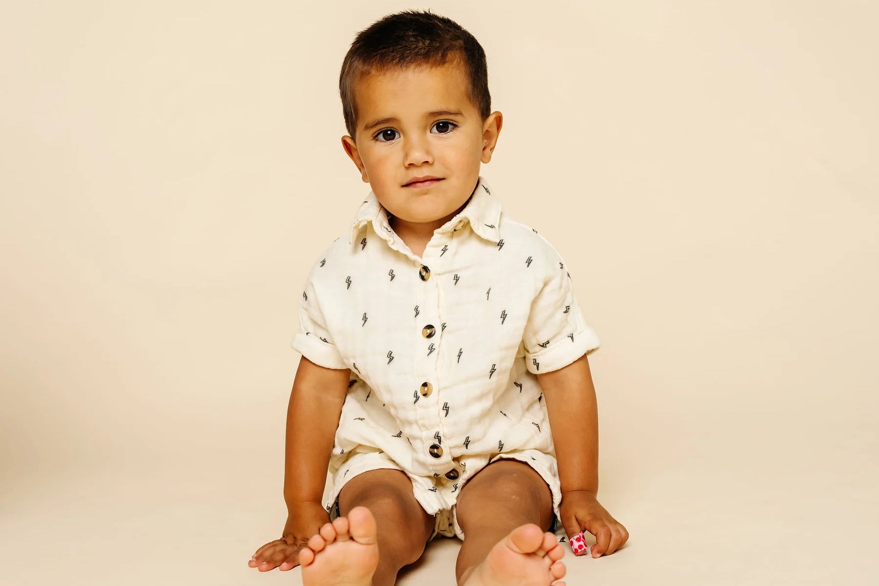 Baby sitting in the Lou Lou & Company Cloud Muslin Shorts and Shirt in Lightning Bolt