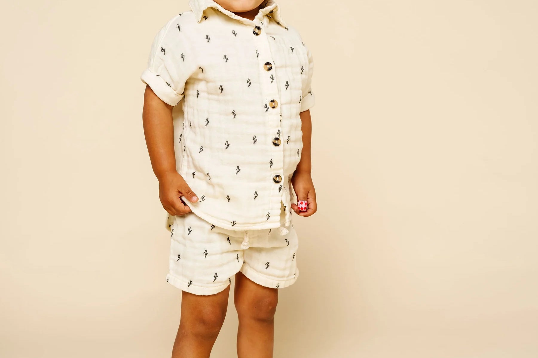 Toddler standing in the Lou Lou & Company Cloud Muslin Shorts and Shirt in Lightning Bolt