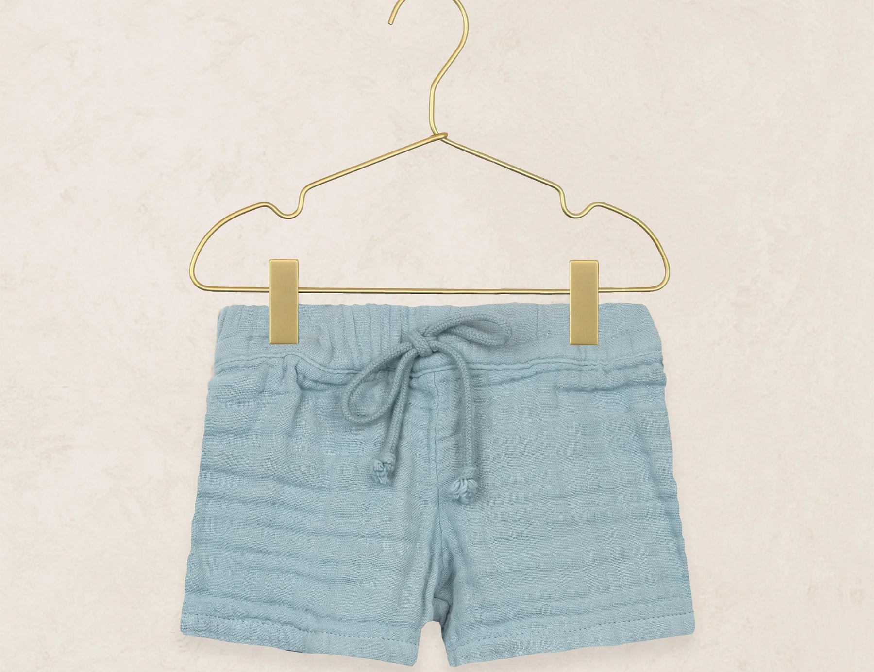Lou Lou & Company Cloud Muslin Shorts in Steel, soft blue drawstring shorts on a hanger