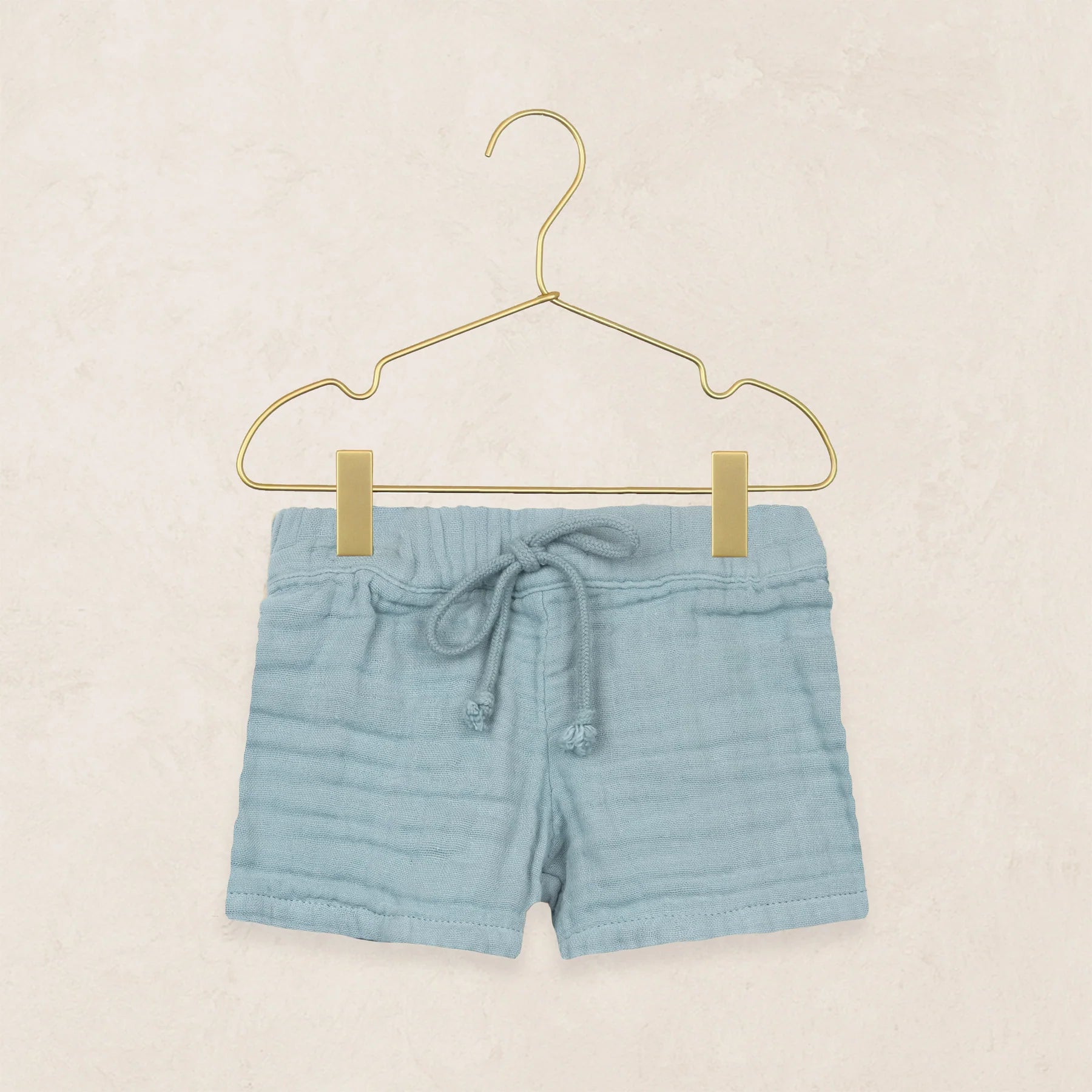 Lou Lou & Company Cloud Muslin Shorts in Steel, soft blue drawstring shorts on a hanger