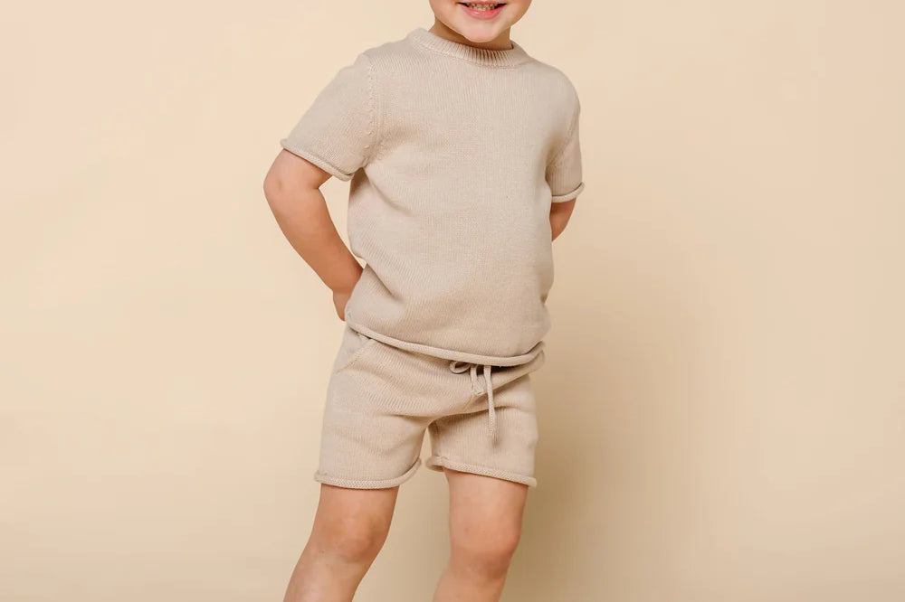 Smiling toddler boy wearing the Lou Lou & Company Knit Tee and Shorts in Tan