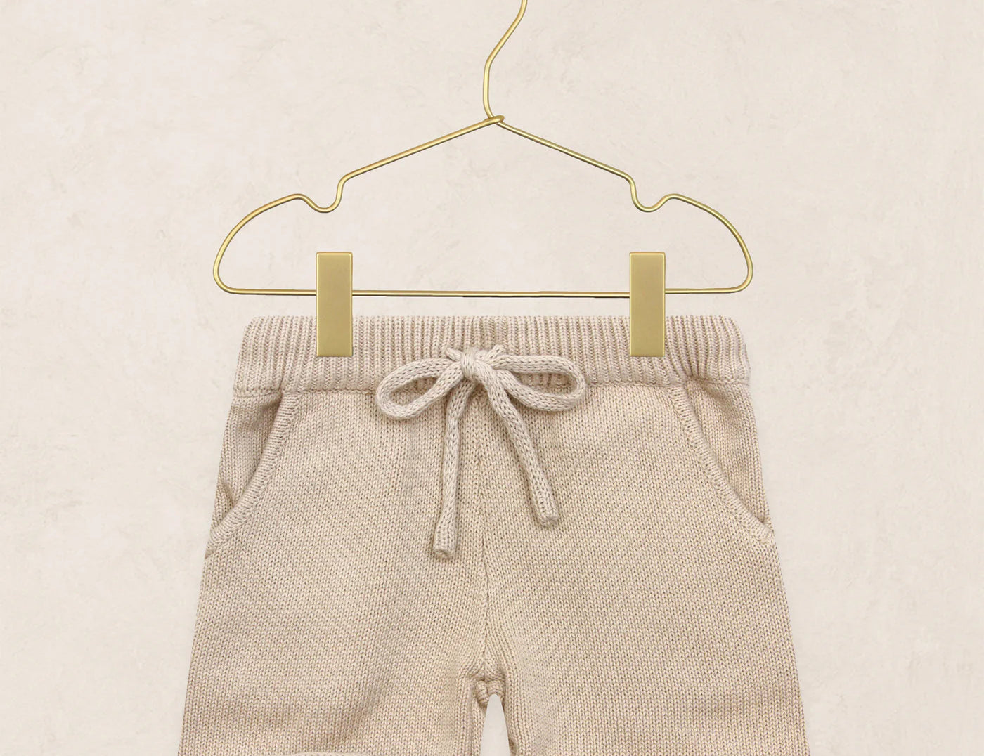 Lou Lou & Company Knit Shorts in Tan, cotton knit drawstring baby shorts on a hanger