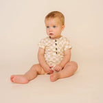 Baby sitting up wearing the Lou Lou & Company Romper in Austin checkered print