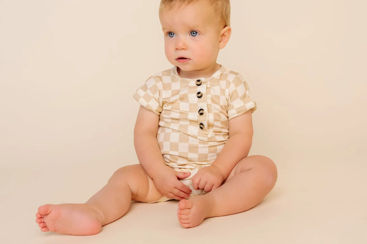 Baby sitting up wearing the Lou Lou & Company Romper in Austin checkered print