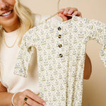 Woman holding up the Lou Lou & Company Romper in Etta on a hanger