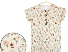 Lou Lou & Company Romper in Rachel, a cream floral short-sleeve henley romper on a hanger