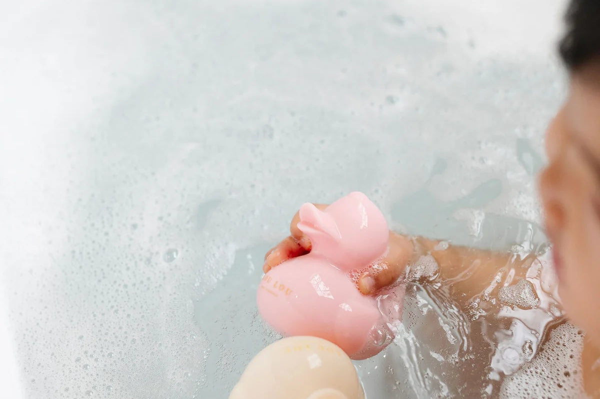 Lou Lou & Company Rubber Duckies in pink and cream floating in a bubble bath