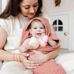 Mother holding a baby in a pink towel with Lou Lou & Company Rubber Duckies in cream and pink