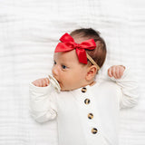 Newborn in a white onesie wearing the Lou Lou & Company Satin Bow in Cherry