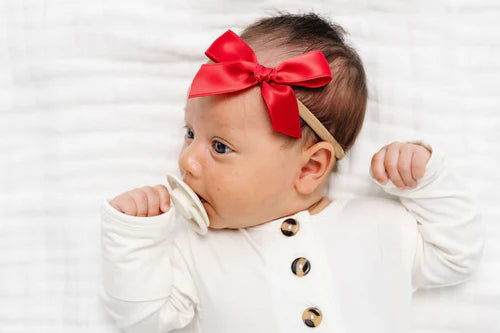 Newborn in a white onesie wearing the Lou Lou & Company Satin Bow in Cherry