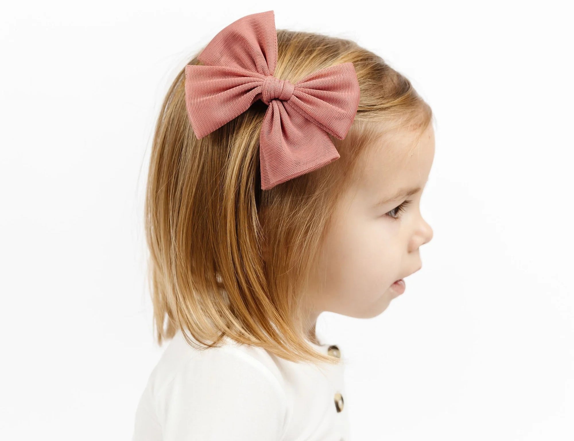 Toddler girl in profile wearing the Lou Lou & Company Tulle Bow Clip in Rose