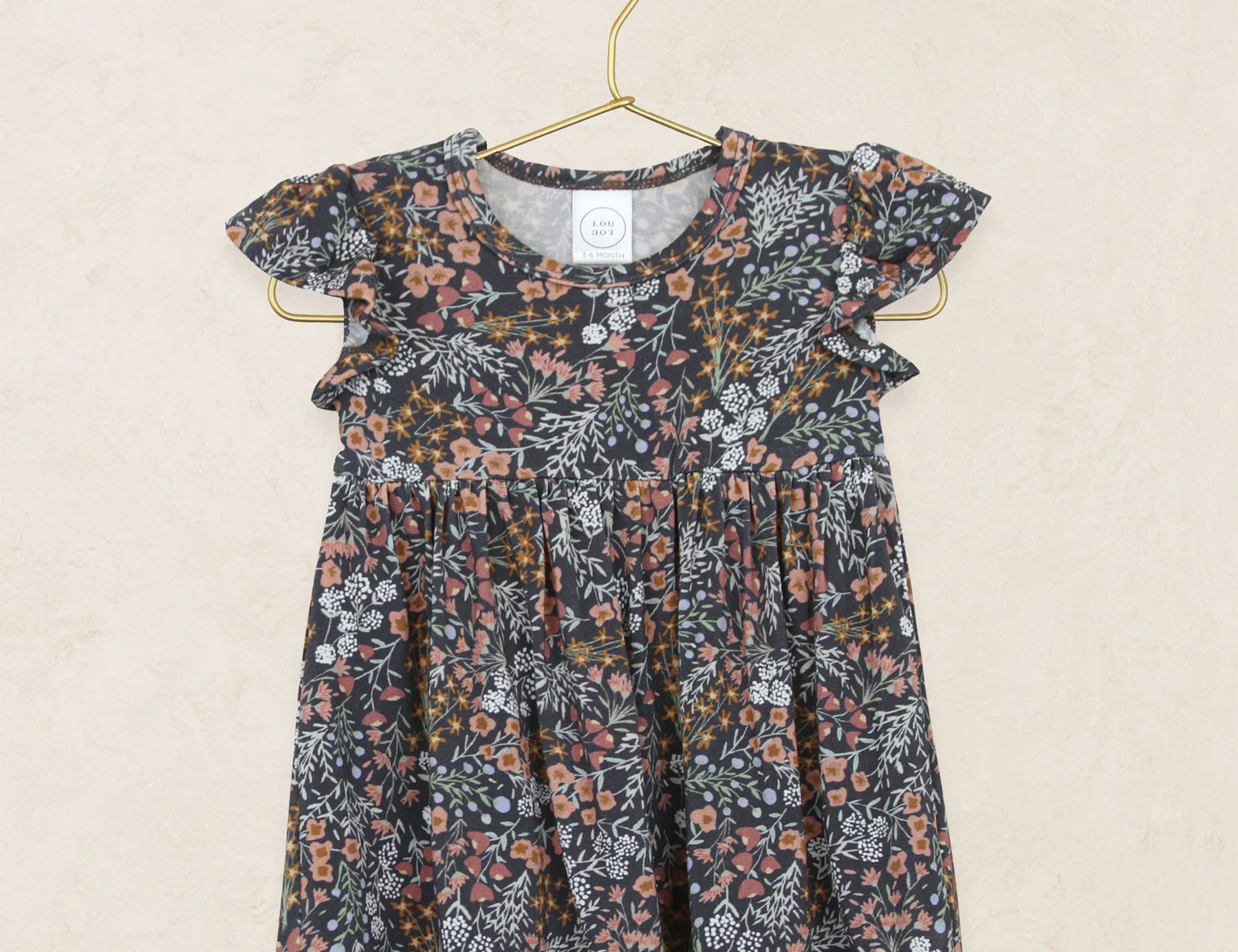 Lou Lou & Company Twirl Dress in Bae, a navy floral flutter-sleeve dress on a hanger