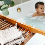 Lou Lou & Company Washcloth in Grey on a wooden bath tray with a toddler in the tub