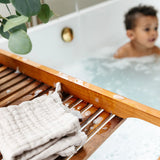 Lou Lou & Company Washcloth in Grey on a wooden bath tray with a toddler in the tub