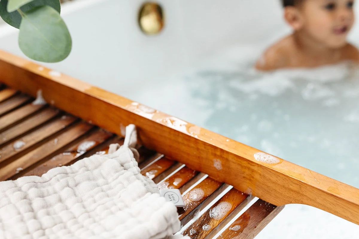 Lou Lou & Company Washcloth in Grey on a wooden bath tray with a toddler in the tub