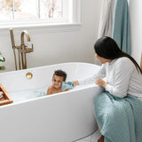 Mother bathing a toddler in a tub with Lou Lou & Company Washcloths in Steel