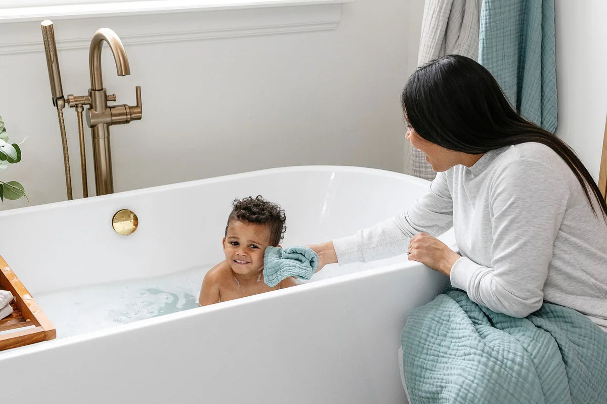 Mother bathing a toddler in a tub with Lou Lou & Company Washcloths in Steel