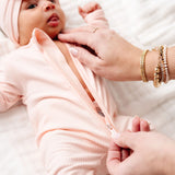 Close-up of the two-way zipper being opened on the Lou Lou & Company Zipper Footies in Rosie