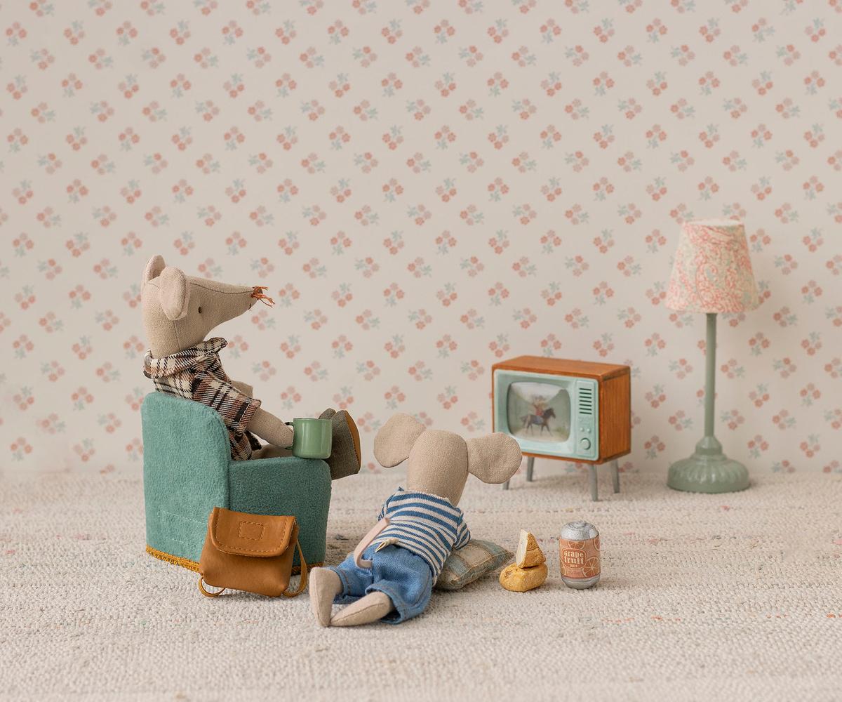 Maileg mouse in a chair watching the miniature Television with a lamp and floral wallpaper
