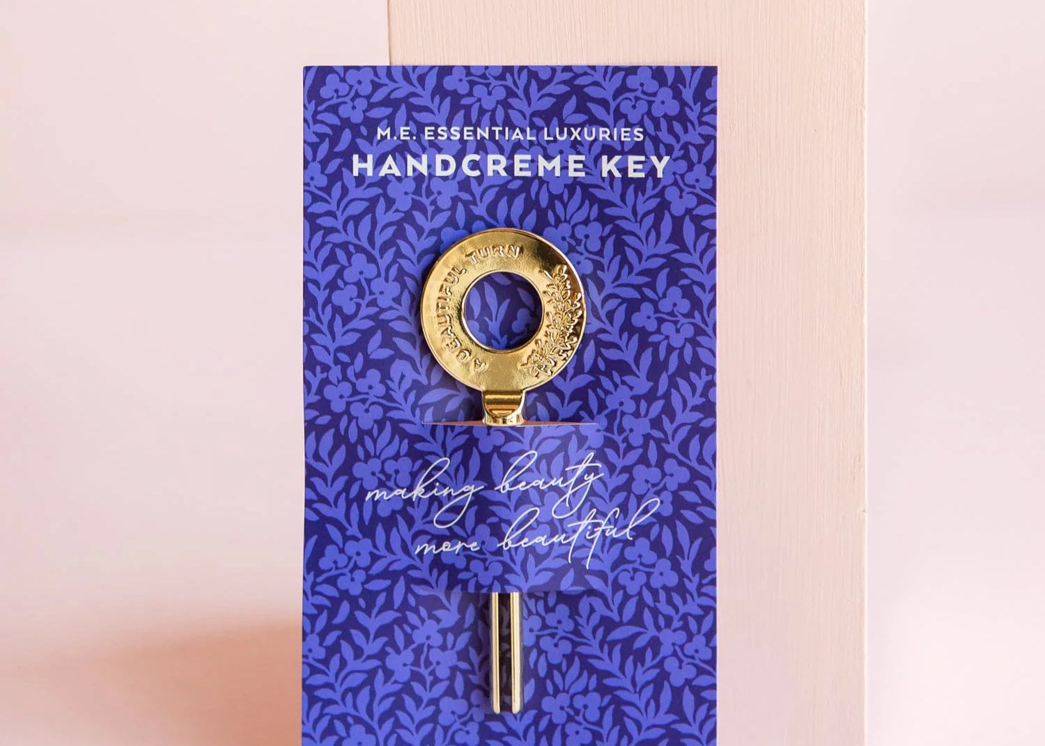 Margot Elena Essential Luxuries handcreme key, a gold key on a deep blue botanical print card