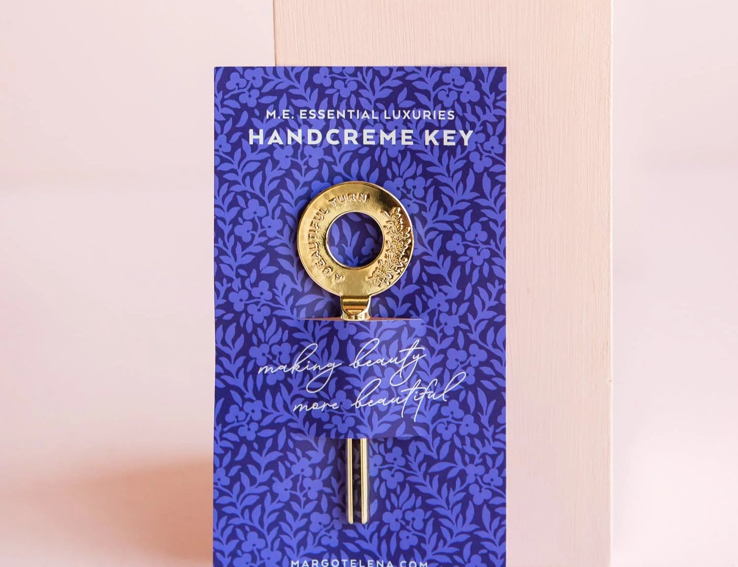 Margot Elena Essential Luxuries handcreme key, a gold key on a deep blue botanical print card
