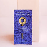 Margot Elena Essential Luxuries handcreme key, a gold key on a deep blue botanical print card