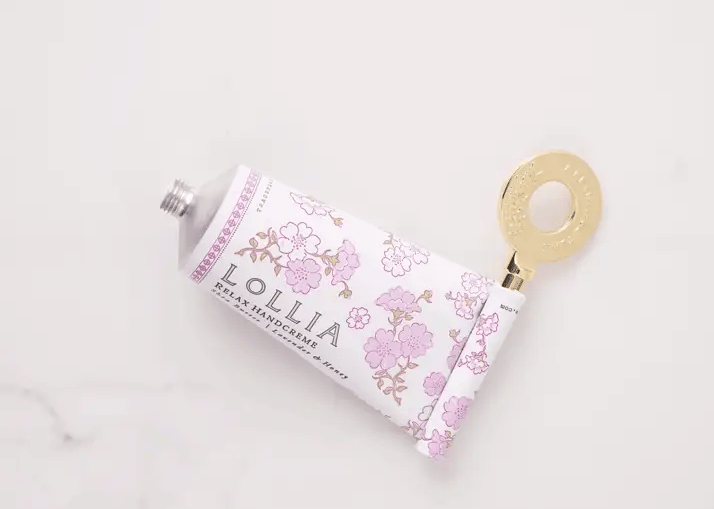 Gold handcreme key rolling up a Lollia Relax handcreme tube