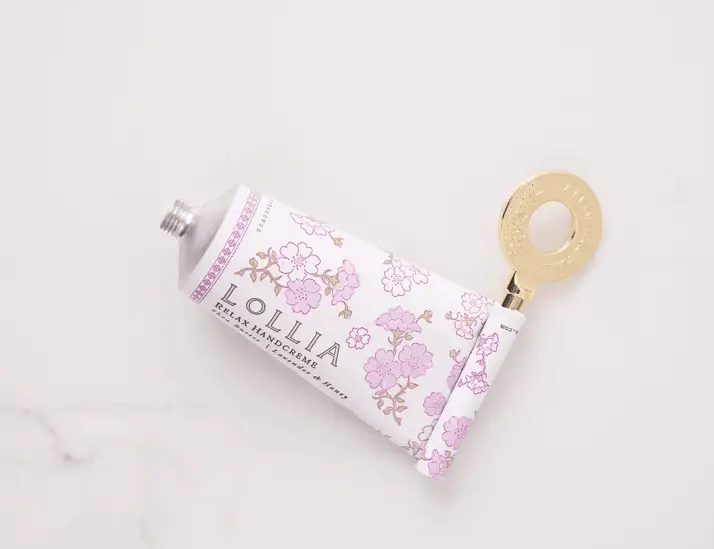 Gold handcreme key rolling up a Lollia Relax handcreme tube