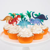 Meri Meri Dinosaur Kingdom Cupcake Kit, cupcakes in orange foil wrappers topped with dinosaur and palm toppers