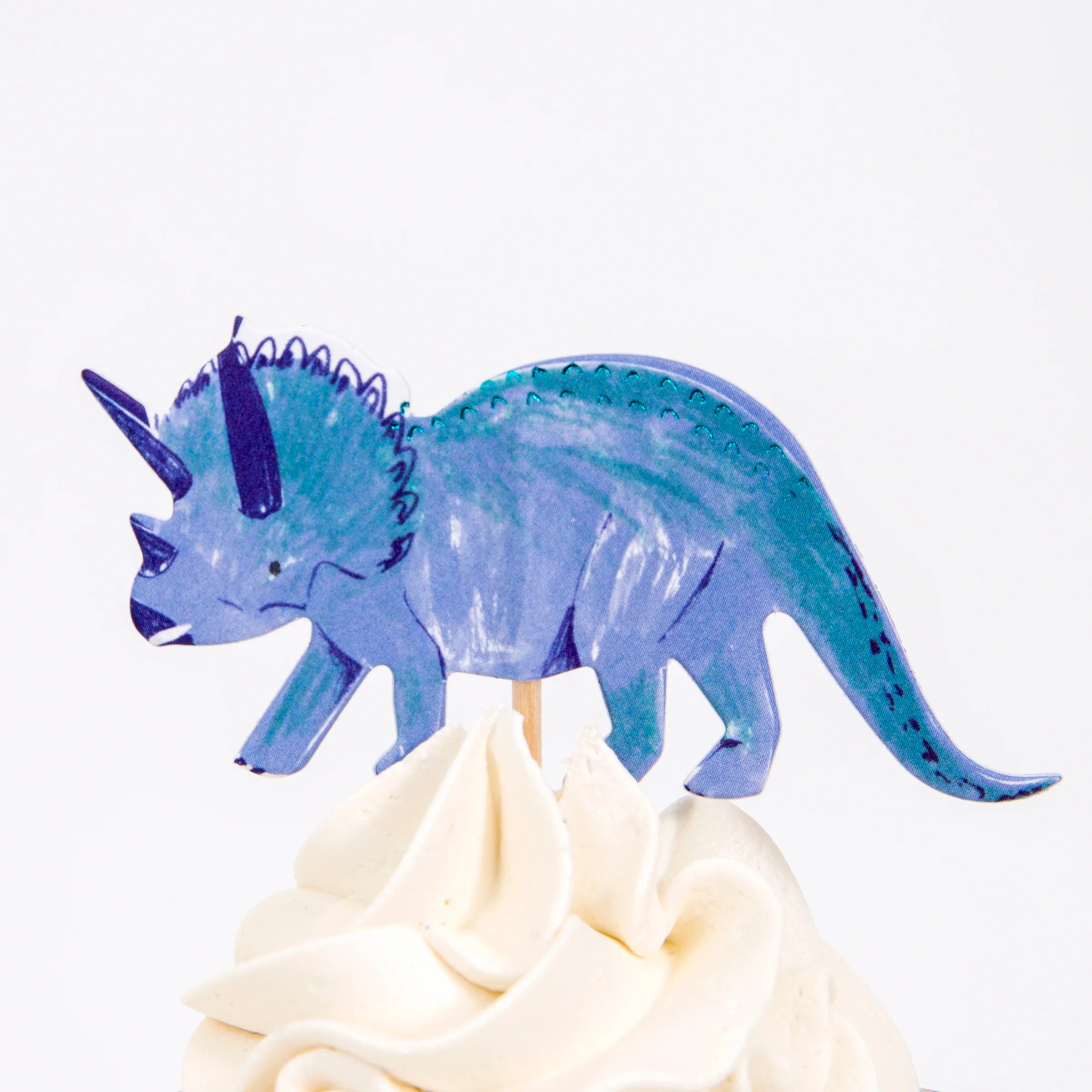 Meri Meri Dinosaur Kingdom Cupcake Kit blue triceratops topper on a frosted cupcake