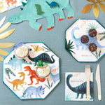 Meri Meri Dinosaur Kingdom Dinner Plates set on a teal tablecloth with cupcakes and dinosaur napkins