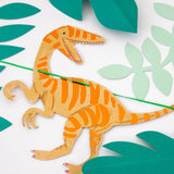 Close-up of the orange velociraptor and paper leaves on the Meri Meri Dinosaur Kingdom Large Garland