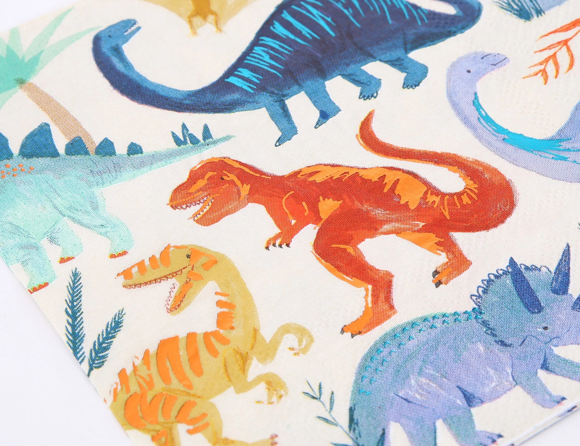 Close-up of the painted T-rex and brachiosaurus print on the Meri Meri Dinosaur Kingdom Large Napkins