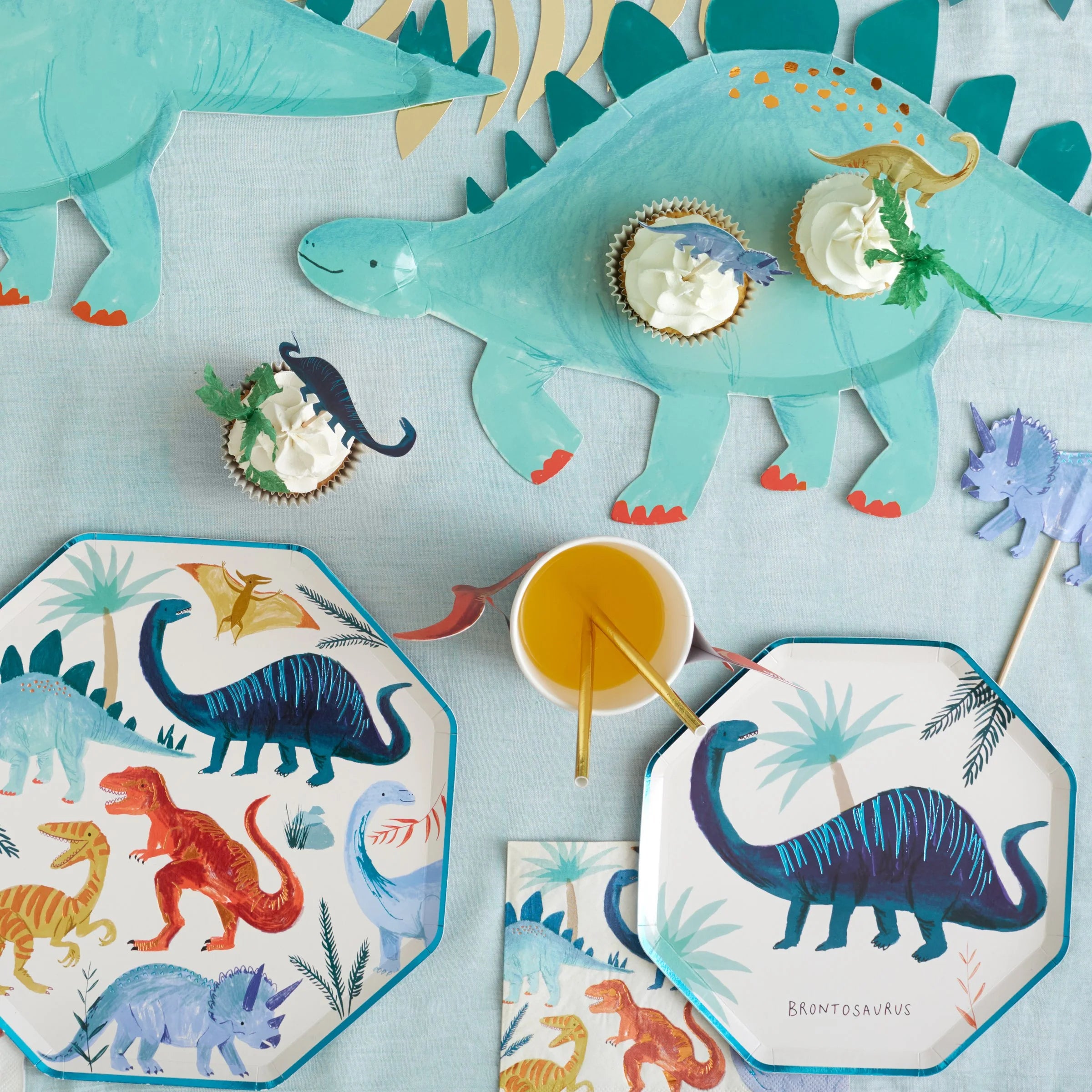 Meri Meri Dinosaur Kingdom Large Napkins on a party table with dinosaur plates and a stegosaurus platter