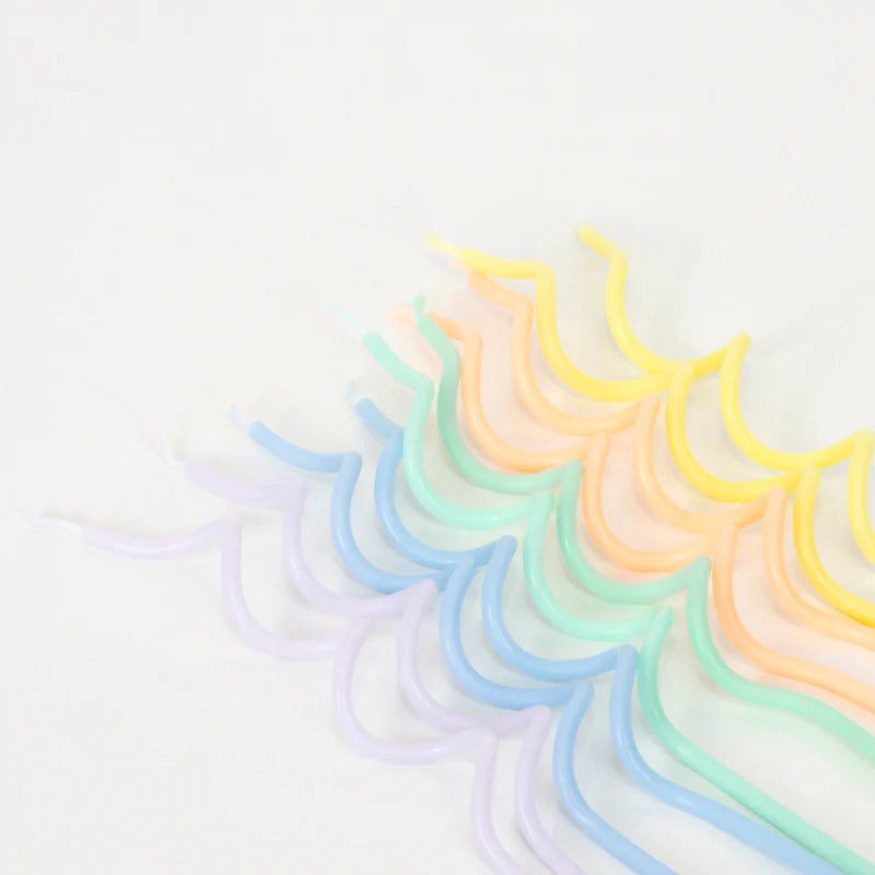 Close-up of Meri Meri Pastel Swirly Candles in lavender, mint, yellow, peach and blue laid in a row