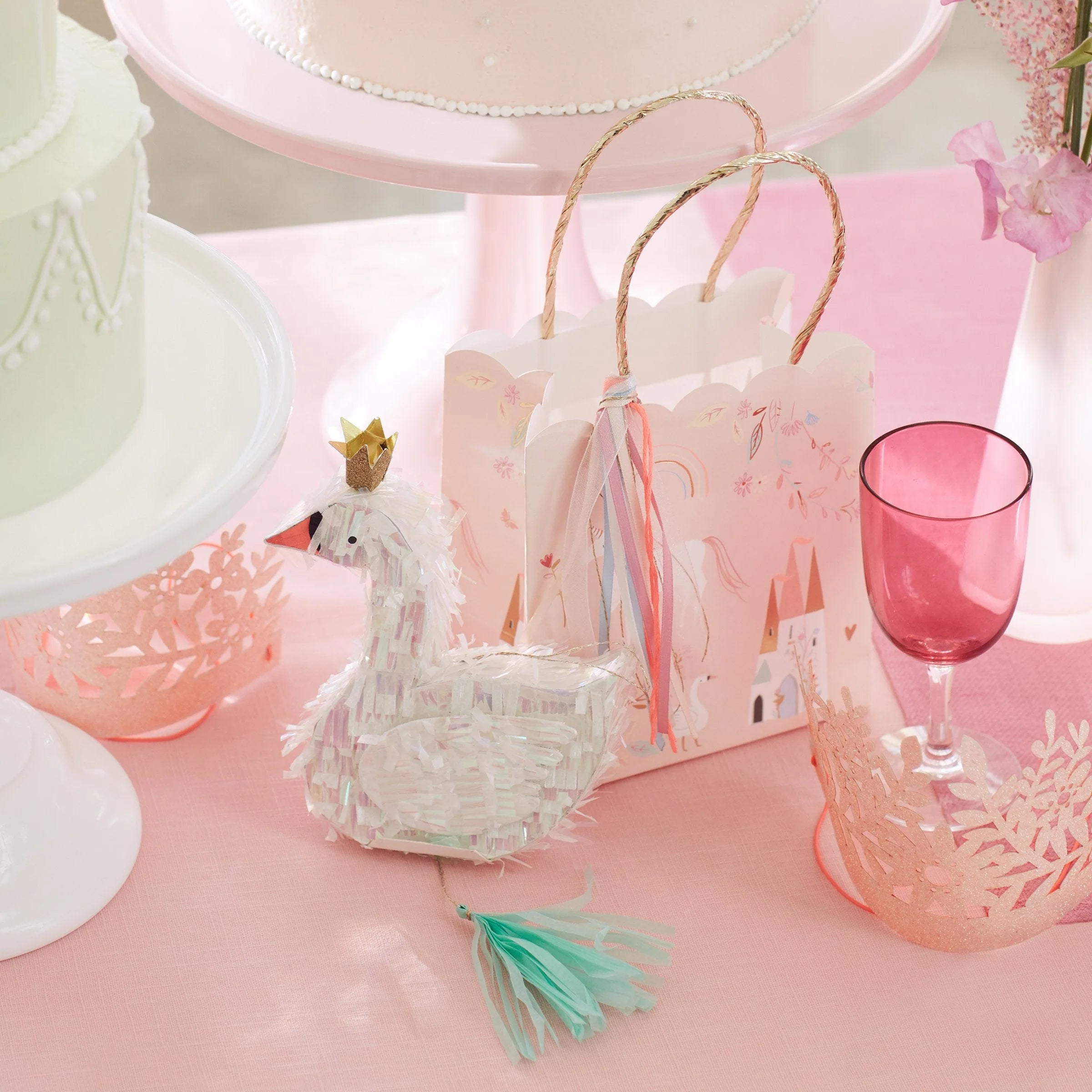 Meri Meri Princess Party Bag on a pink party table with a swan cake topper and a pink glass
