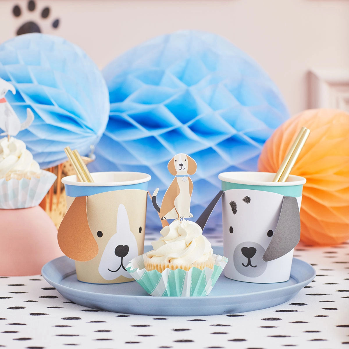 Meri Meri Puppy Cupcake Kit cupcakes on a party table with blue honeycomb decorations and dog cups