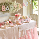 Meri Meri Scallop Edge Baby Garland hung over a baby shower table with flowers and cakes