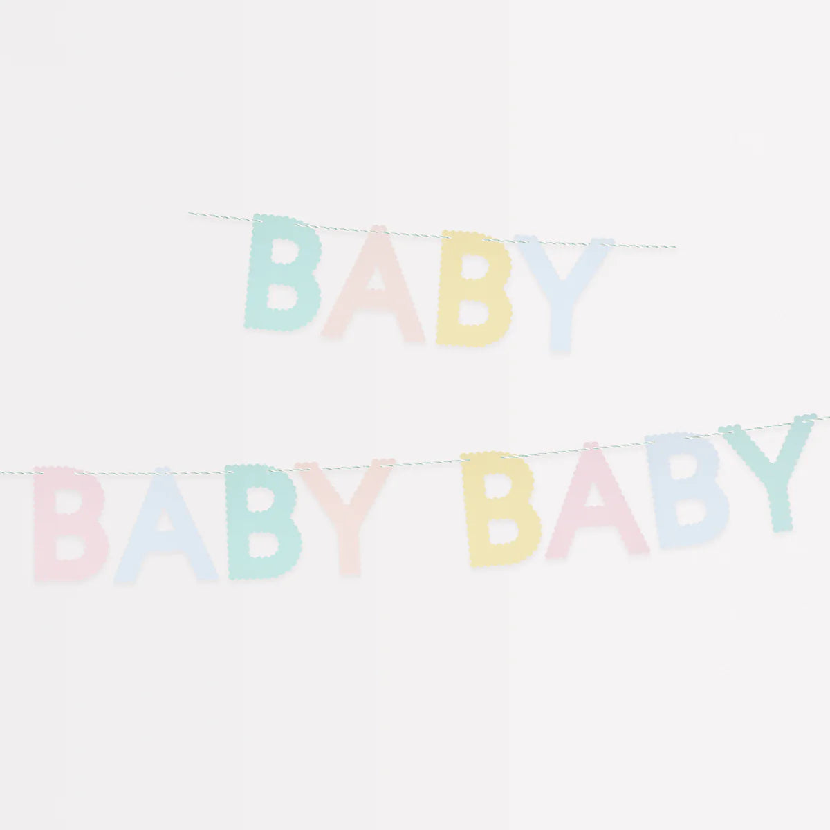 Meri Meri Scallop Edge Baby Garland hung in two rows against a white wall