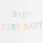 Meri Meri Scallop Edge Baby Garland hung in two rows against a white wall