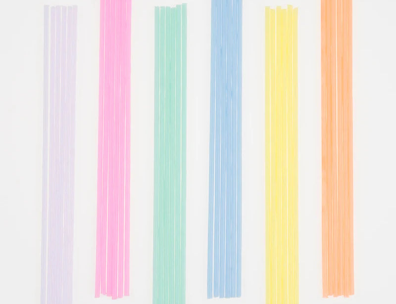 Meri Meri Super Skinny Mixed Candles in lilac, pink, mint, blue, yellow and orange laid in a row